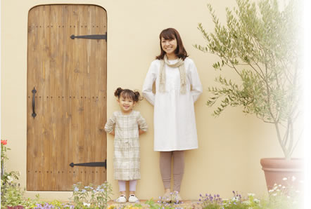 玄関前で待つ笑顔の妻と娘